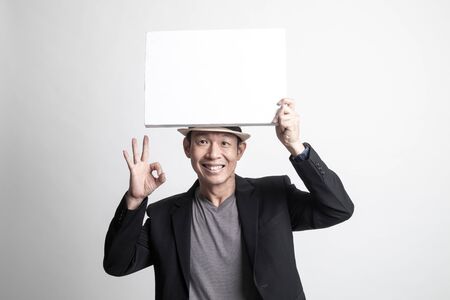 Adult Asian man  show OK with  white blank sign on white backgroundの写真素材