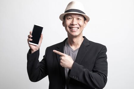Adult Asian man point to mobile phone on white backgroundの写真素材