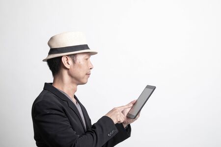 Adult Asian man  with a computer tablet on white backgroundの写真素材