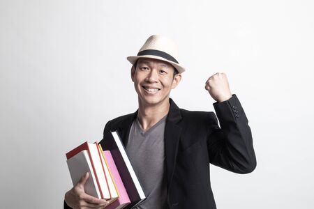 Adult Asian man studying  with may books on white backgroundの写真素材