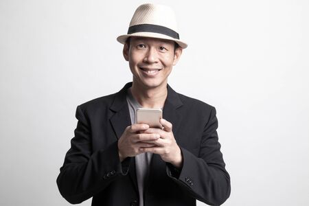 Adult Asian man with mobile phone on white backgroundの写真素材