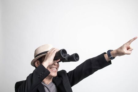 Adult Asian man   point and look with binoculars on white backgroundの写真素材