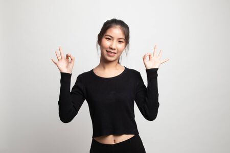 Asian woman show double OK hand sign  and smile on white backgroundの写真素材