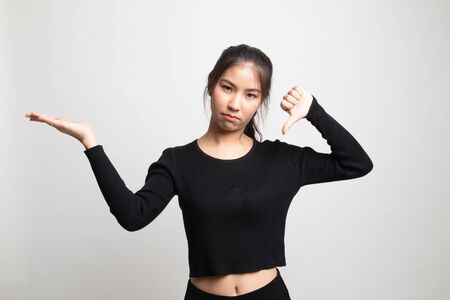 Young Asian woman show palm hand and thumbs down on white backgroundの写真素材
