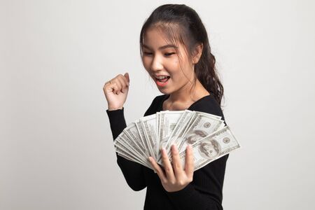 Portrait of  young asian woman  showing bunch of money banknotes on white backgroundの写真素材