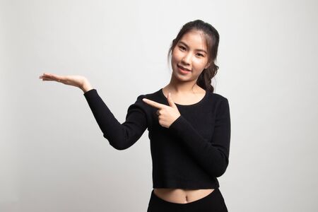 Beautiful young Asian woman point to palm hand on white backgroundの写真素材