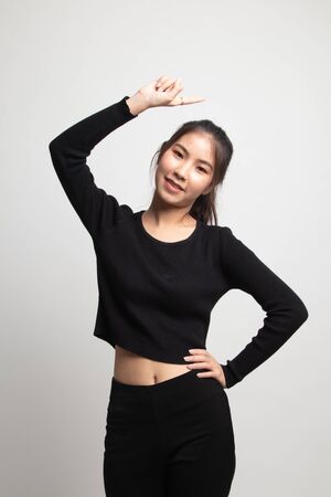 Young Asian woman smile and point up on white backgroundの写真素材