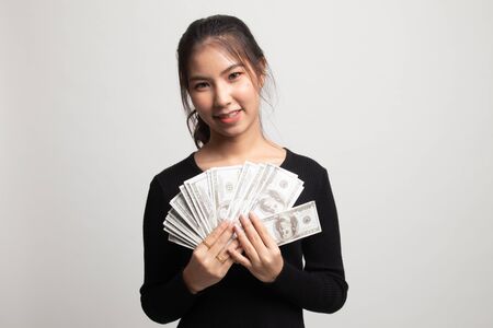 Portrait of  young asian woman  showing bunch of money banknotes on white backgroundの写真素材