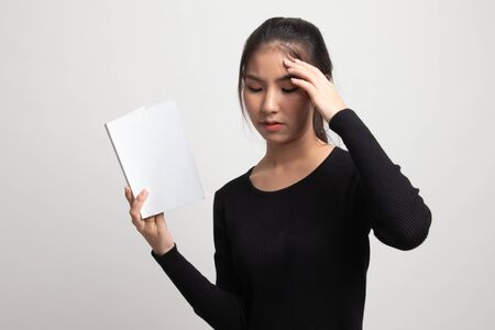 Young Asian woman got headache read a book on white backgroundの写真素材