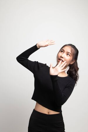 Excited young Asian woman look up on white backgroundの写真素材