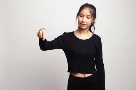 Beautiful young Asian woman point down to blank space on white backgroundの写真素材