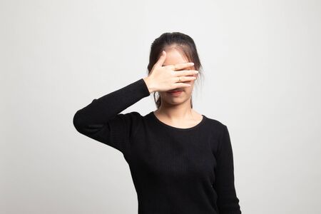 Young Asian woman close her eyes with hand on white backgroundの写真素材