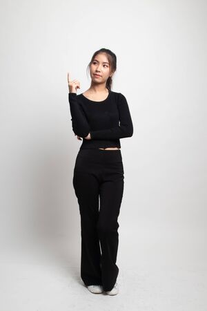Full body of beautiful young asian woman pointing up on white backgroundの写真素材