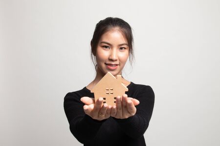 Happy young asian woman with house model on white backgroundの写真素材