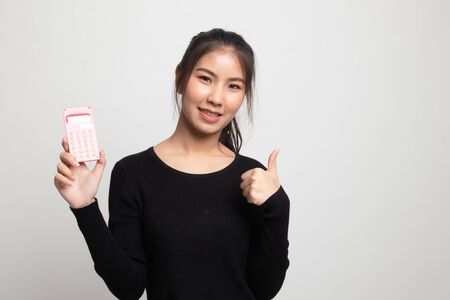 Asian woman thumbs up with calculator on white backgroundの写真素材