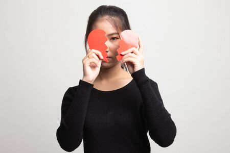 Beautiful young Asian woman with broken heart on white backgroundの写真素材