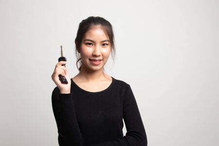 Cute asian girl showing home residence keys on white backgroundの写真素材