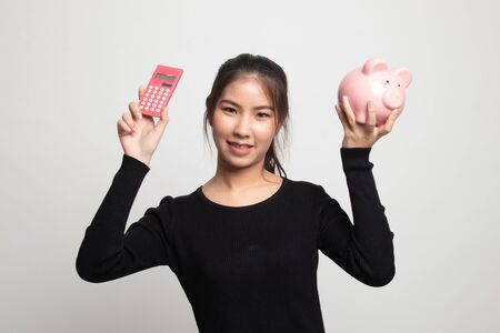 Asian woman with calculator and piggy bank on white backgroundの写真素材