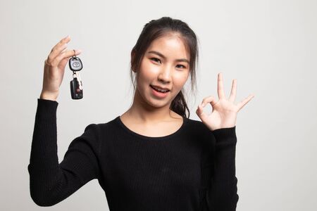Cute asian girl showing home residence keys on white backgroundの写真素材