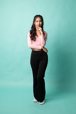 Full body of beautiful young asian woman on cyan backgroundの写真素材