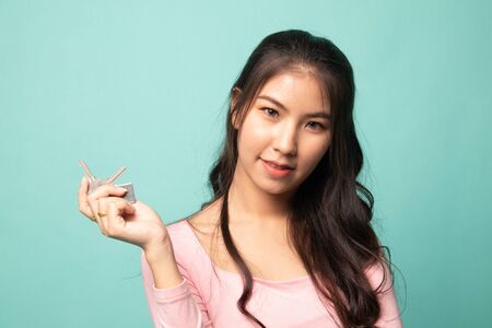 Cute asian girl showing home residence keys on cyan backgroundの写真素材