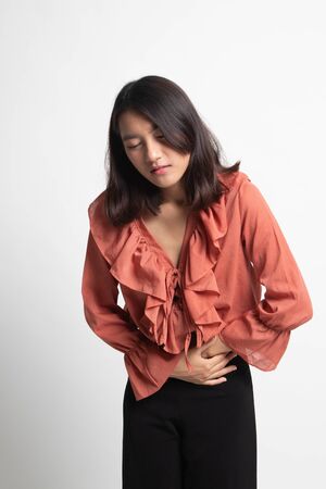 Young Asian woman got stomachache on white backgroundの写真素材