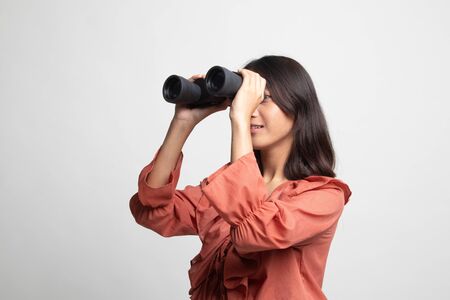 Young Asian woman with binoculars on white backgroundの写真素材