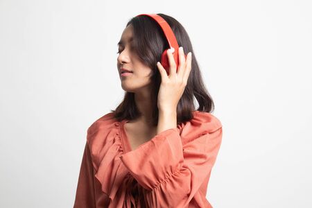 Pretty asian girl listening music with her headphones on white backgroundの写真素材
