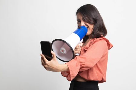 Angry  young Asian woman shout with megaphone to mobile phone on white backgroundの写真素材