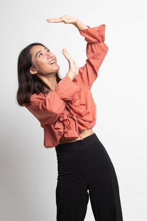 Excited young Asian woman look up on white backgroundの写真素材