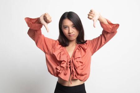 Unhappy Asian girl show thumbs down with both hands on white backgroundの写真素材