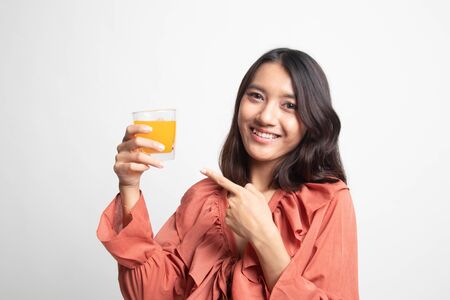 Young Asian woman point to orange juice on white backgroundの写真素材