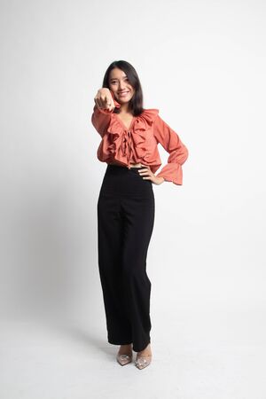 Full body of beautiful young asian woman pointing on white backgroundの写真素材