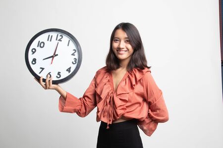 Young Asian woman with a clock on white backgroundの写真素材