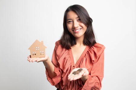 Young asian woman with house model and money coin on white backgroundの写真素材