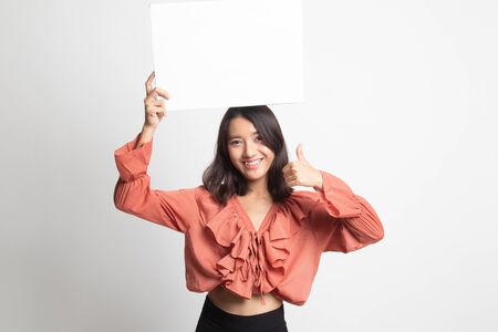 Young Asian woman show thumbs up with white blank sign on white backgroundの写真素材