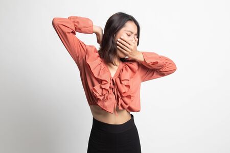 Sleepy young Asian woman yawn on white backgroundの写真素材