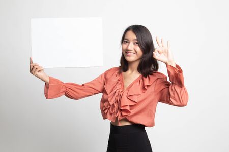 Young Asian woman show OK with  white blank sign on white backgroundの写真素材