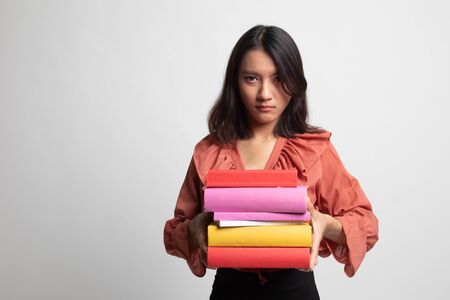 Unhappy young Asian woman studying  with may books on white backgroundの写真素材