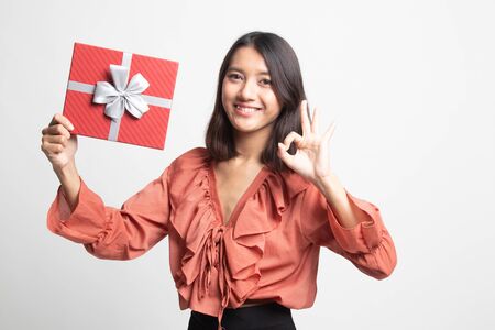 Young Asian woman show OK with a gift box on white backgroundの写真素材