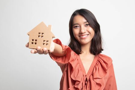 Happy young asian woman with house model on white backgroundの写真素材