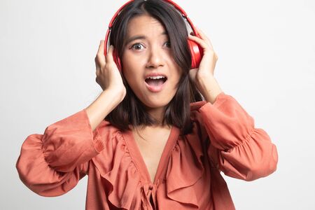 Pretty asian girl listening music with her headphones on white backgroundの写真素材