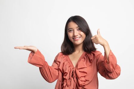Beautiful young Asian woman show palm hand and thumbs up on white backgroundの写真素材