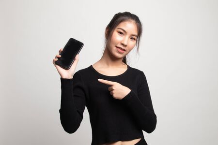 Young Asian woman point to mobile phone on white backgroundの写真素材