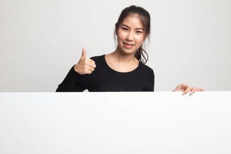Young Asian woman show thumbs up with blank sign on white backgroundの写真素材