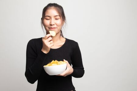 Young Asian woman eat potato chips on white backgroundの写真素材
