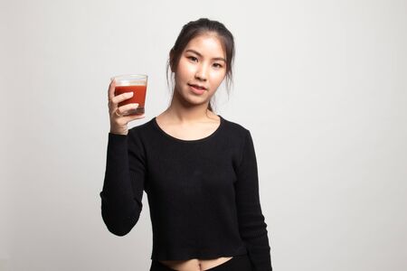 Young Asian woman drink tomato juice on white backgroundの写真素材