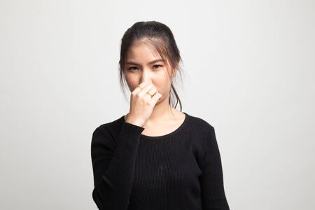Young Asian woman  holding her nose because of a bad smell on white backgroundの写真素材