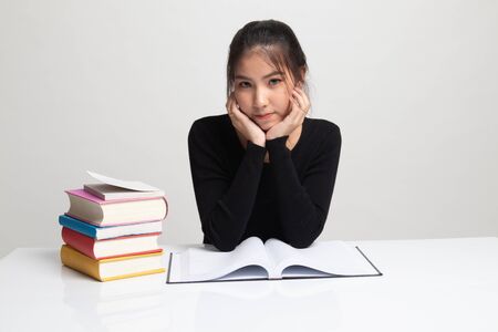 Young Asian woman read a book with books on table on white backgroundの写真素材