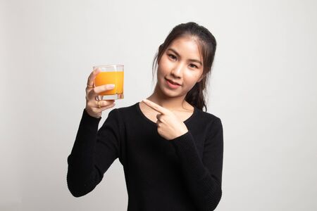 Young Asian woman point to orange juice on white backgroundの写真素材